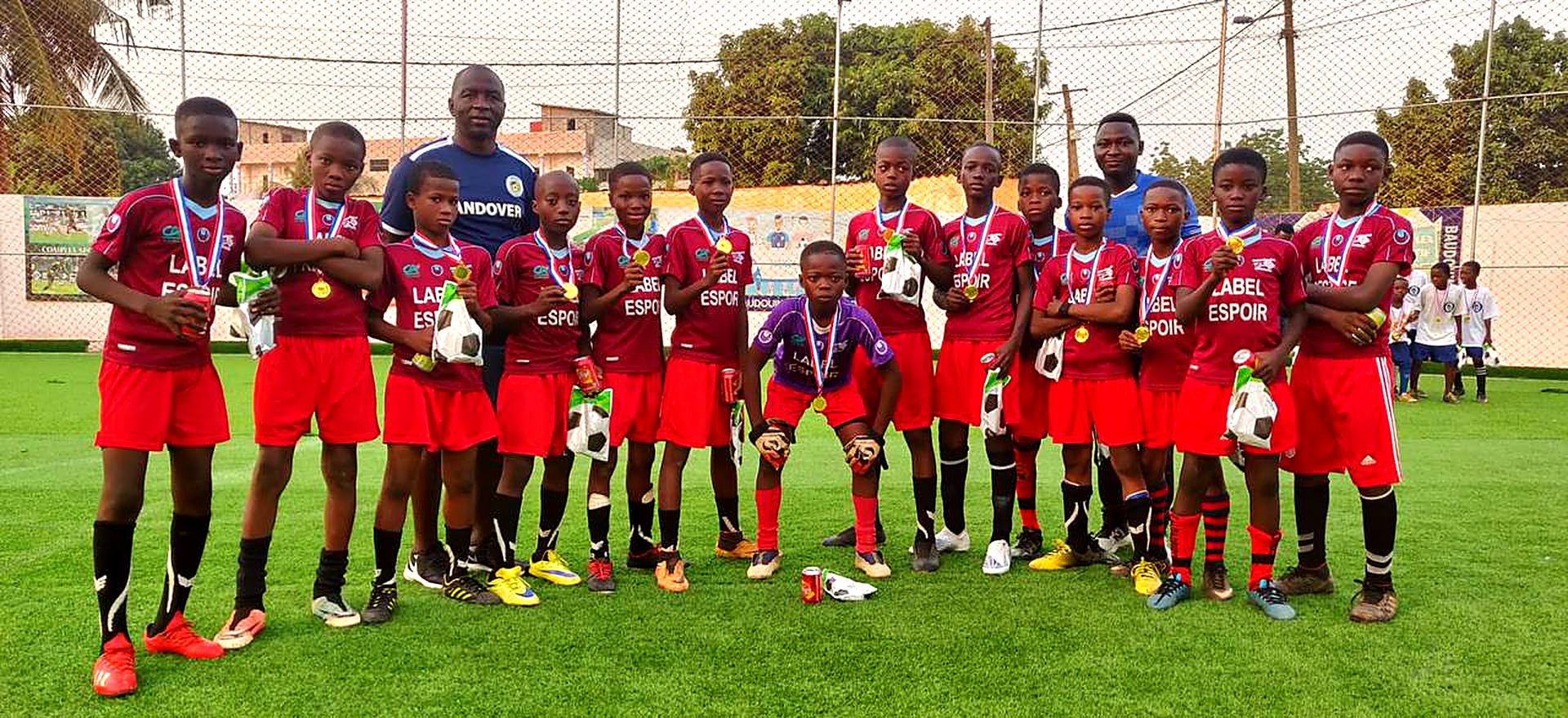 Youth soccer team celebrating with medals on the pitch